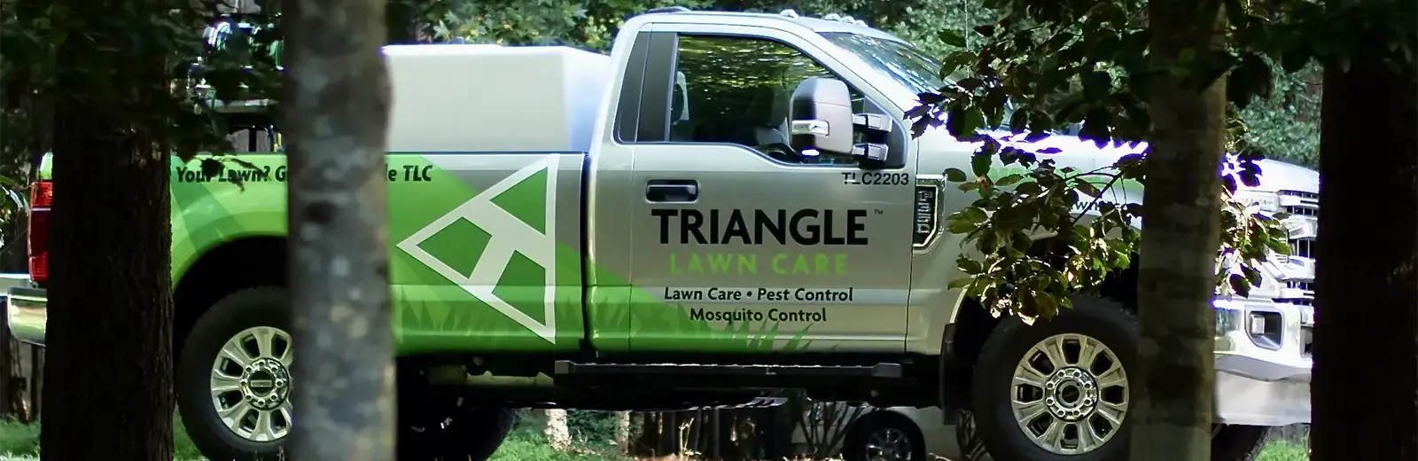 Triangle Lawn Care truck parked outside home