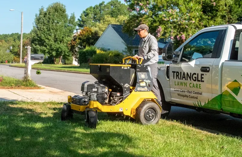 technician aerating lawn