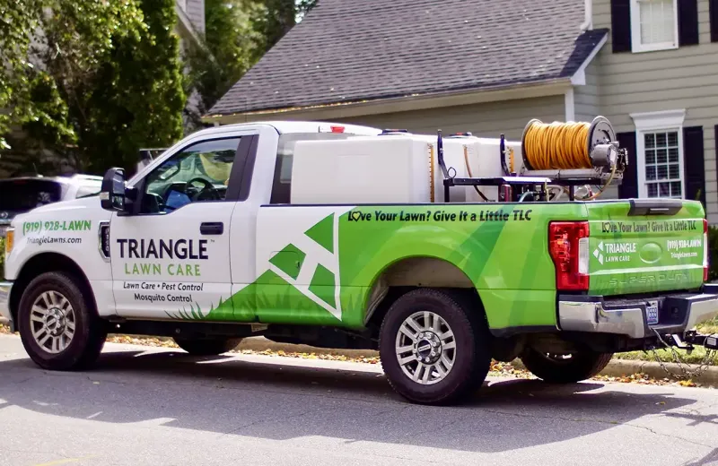 Triangle Lawn Care truck in front of clients home